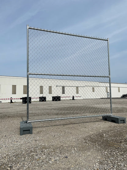 Temporary chain link fence panel set up outdoors with a durable galvanized steel frame and weighted bases, ideal for construction sites and event security.